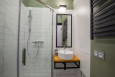 Łazienka z białymi płytkami na ścianie oraz zielonym kolorem ścian