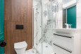 Mała łazienka z prysznicem narożnym z imitacją drewna na ścianie oraz marmuru