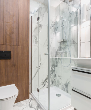 Mała łazienka z prysznicem narożnym z imitacją drewna na ścianie oraz marmuru