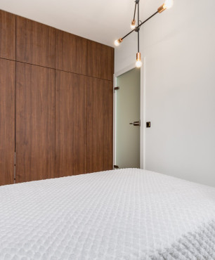Mała i funkcjonalna sypialnia z szafą w zabudowie pod sufit z frontem w kolorze wenge