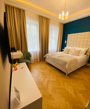Nowoczesna sypialnia hotelowa z dużym łóżkiem kontynentalnym z białym zagłówkiem tapicerowanym