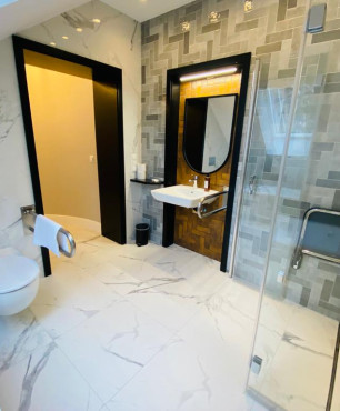 Duża, nowoczesna łazienka przystosowana dla osób niepełnosprawnych