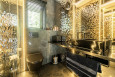 Nowoczesna łazienka ze złotym akcentem na ścianie oraz z czarną muszlą wiszącą