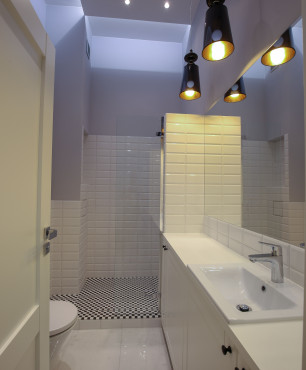 Nowoczesna łazienka z prysznicem oraz czarnymi lampami wiszącymi