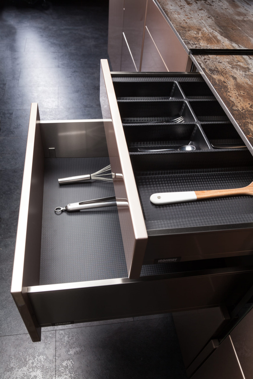 Kuchnia z ergonomicznymi szafkami oraz czarnymi płytkami na podłodze