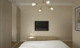 Sypialnia z szafą z lustrem, szafką RTV, telewizorem na ścianie oraz łóżkiem