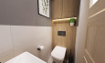 Małe wc z drewnem na ścianie