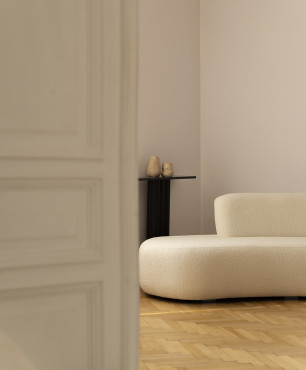 Klasyczny salon z drewnianym parkietem oraz wyjątkową, tapicerowaną sofą