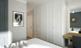 Sypialnia z białą szafą w zabudowie pod sufit
