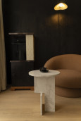 Salon z brązowym, tapicerowanym fotelem oraz białym stolikiem kawowym