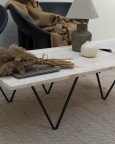 Salon z kamiennym, prostokątnym stolikiem na ,metalowych nogach