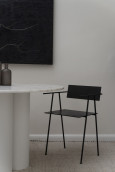 Salon z białym, okrągłym stołem z czarnym krzesłem