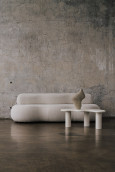 Salon w stylu loft z tapicerowaną sofą w kolorze kremowym oraz stolikiem kawowym
