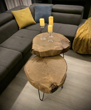 Salon z szarym narożnikiem oraz stolikami drewnianymi
