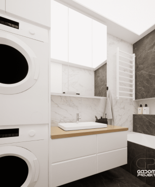 Projekt łazienki z białą szafką wiszącą z drewnianym blatem, suszarką bębnową oraz pralką