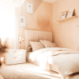 Sypialnia z tapicerowanym łóżkiem oraz ścianami w beżowym kolorze