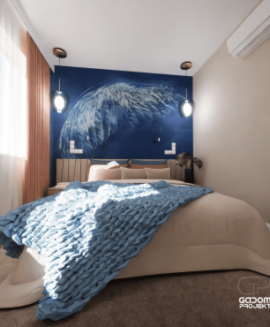 Sypialnia z łóżkiem kontynentalnym oraz niebieską tapetą ze skrzydłem anioła na ścianie