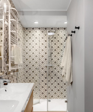 Łazienka z prysznicem oraz wzorzystymi płytkami na ścianie