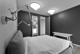 Sypialnia z tapicerowanym łóżkiem oraz szarym kolorem ścian