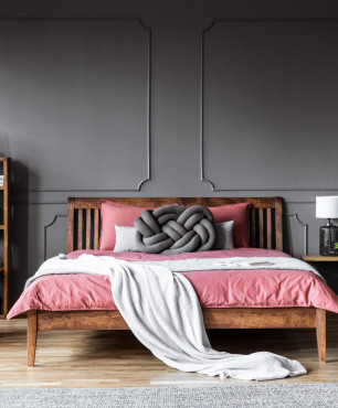 Sypialnia z drewnianym łóżkiem na nóżkach