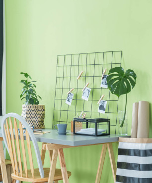 Małe biurko przy zielonej ścianie