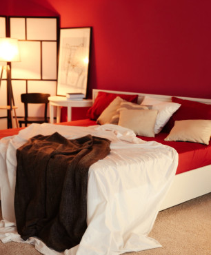 Białe łóżko w czerwonej sypialni