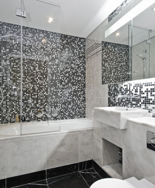 Łazienka z marmurową wanną i czarno-białą mozaiką
