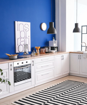 Nowoczesna biała kuchnia z niebieska ścianą