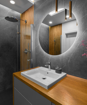 Łazienka z okrągłym lustrem i drewnem na ścianie