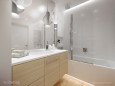 Biała łazienka z szafka w kolorze jasnego drewna
