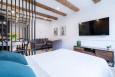 Aranżacja sypialni z drewnianymi elementami na suficie