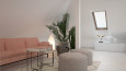 Salon na poddaszu z różowa sofa