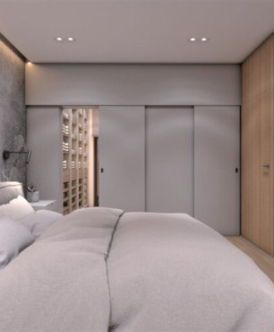 Sypialnia z dużym, tapicerowanym łóżkiem kontynentalnym i garderobą z zasuwanymi drzwiami