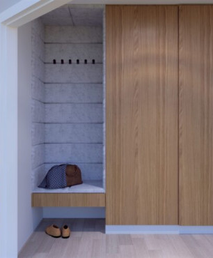 Wejście do mieszkania z siedziskiem i dużą drewnianą szafą