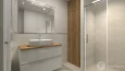 Łazienka z jasnymi płytkami 3d i prysznicem z przesuwanymi drzwiami