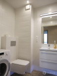 Łazienka z białą muszlą wiszącą i poziomymi płytkami