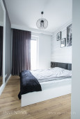 Sypialnia z białym, drewnianym łóżkiem kontynentalnym